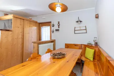 a dining room with a wooden table and chairs at Casa Caracoi in Rocca Pietore