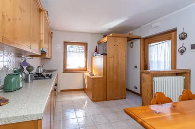 a kitchen with wooden cabinets and a counter top at Casa Caracoi in Rocca Pietore