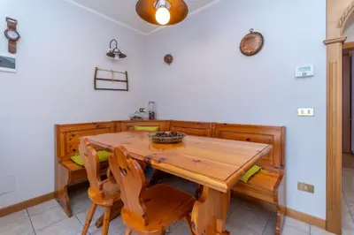 a dining room with a wooden table and chairs at Casa Caracoi in Rocca Pietore