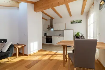 a kitchen and living room with a wooden table and chairs at Winterlehof in Tires