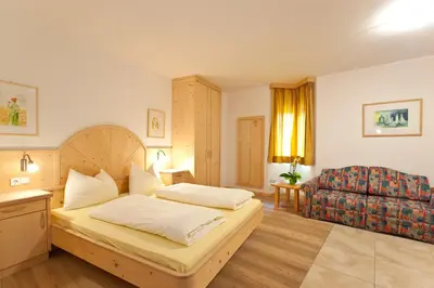 a hotel room with a bed and a chair at Gleifhof in Appiano sulla Strada del Vino