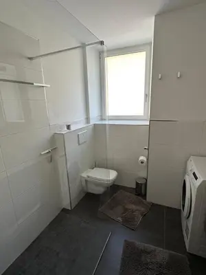 a white bathroom with a toilet and a window at Saringerhof in Rablà