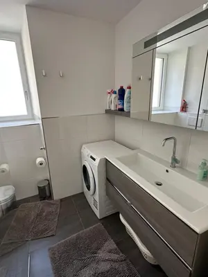 a bathroom with a sink and a washing machine at Saringerhof in Rablà
