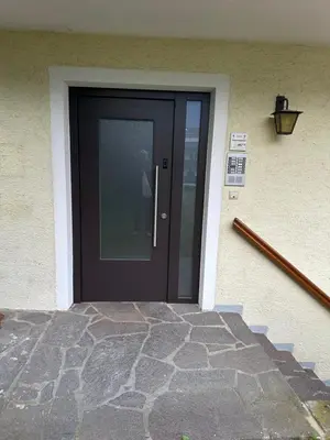 a black door on a house with a stone walkway at Saringerhof in Rablà