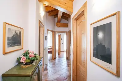 a hallway with white walls and wooden ceilings at La Casa Verde in Canale San Bovo