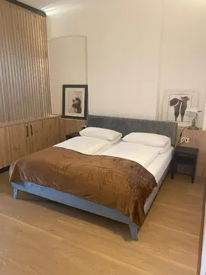 a bedroom with a bed with white sheets and pillows at Appartament Tribulaun in Colle Isarco