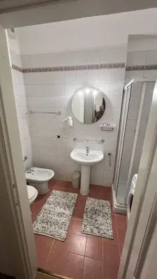 a bathroom with a sink and a toilet and a mirror at Appartament Tribulaun in Colle Isarco