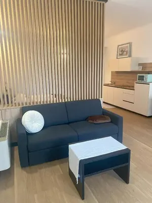 a living room with a blue couch and a table at Appartament Tribulaun in Colle Isarco
