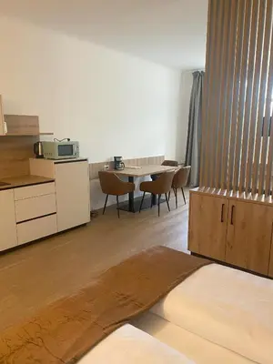 a room with a kitchen and a table with chairs at Appartament Tribulaun in Colle Isarco