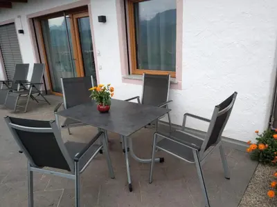 a table and chairs with a vase of flowers on it at Haus Gläserer apartments in Villandro
