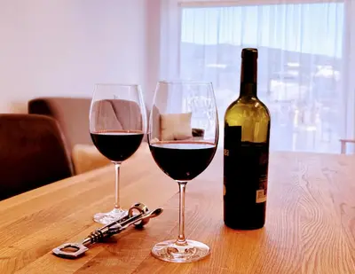 a bottle of wine and two glasses on a table at Haus Gläserer apartments in Villandro