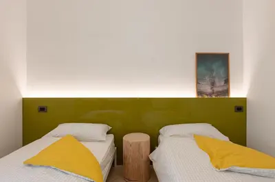 a bedroom with two beds with yellow pillows at La Finestra sul Peller, Coredo Ospitar in Coredo