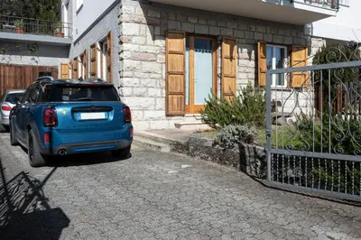 a blue suv parked in front of a house at La Finestra sul Peller, Coredo Ospitar in Coredo