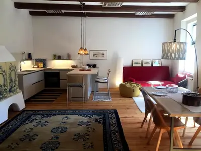 a kitchen and living room with a table and a dining room at Schöne Altstadtwohnung im Herzen der Stadt in Bolzano