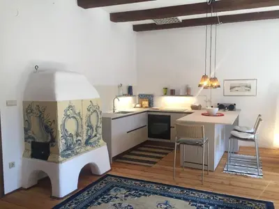 a living room with a kitchen with a table at Schöne Altstadtwohnung im Herzen der Stadt in Bolzano