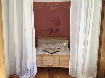 a small bed with white curtains in a room at Schöne Altstadtwohnung im Herzen der Stadt in Bolzano