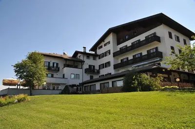a large white building with a grassy hill in front of it at Enrosadira in Predaia