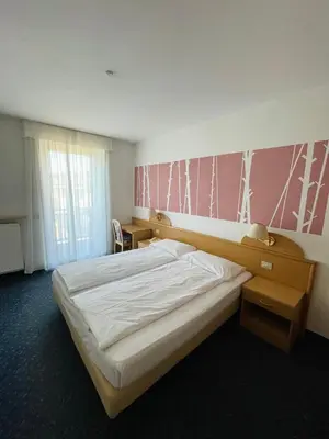 a bedroom with a bed and a pink wall at Enrosadira in Predaia
