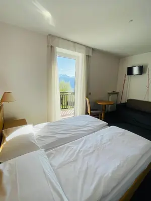 a large white bed in a room with a window at Enrosadira in Predaia