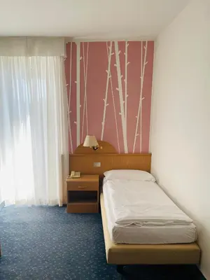 a small bedroom with a bed and a nightstand at Enrosadira in Predaia