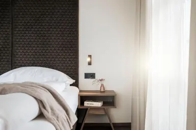 a bedroom with a bed and a green wall at Bella Posta Hotel in Soprabolzano