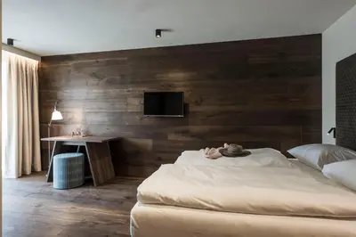 a room with a wooden desk and a blue stool at Bella Posta Hotel in Soprabolzano