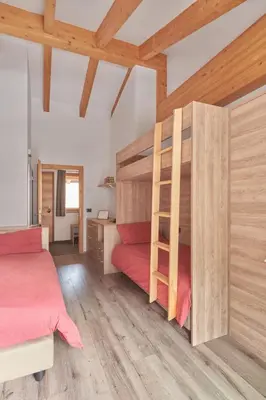a bedroom with two bunk beds and a desk at Sass Pordoi Moena in Moena