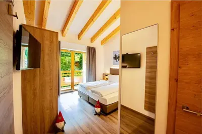 two pictures of a bedroom with a bed and a window at Sass Pordoi Moena in Moena