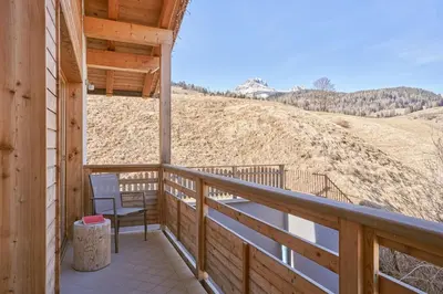 a porch with a chair and a view of a hill at Sass Pordoi Moena in Moena