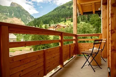 a balcony with a chair and a view of a mountain at Sass Pordoi Moena in Moena