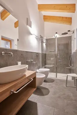 a bathroom with two sinks and a shower and two toilets at Sass Pordoi Moena in Moena