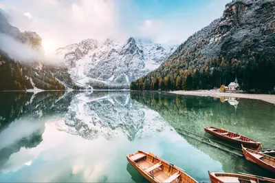 two boats on a lake in front of a mountain at Hotel Bad Waldbrunn in Monguelfo