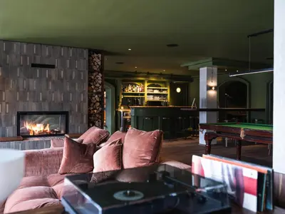 a living room with a couch and a pool table at Hotel Bad Waldbrunn in Monguelfo