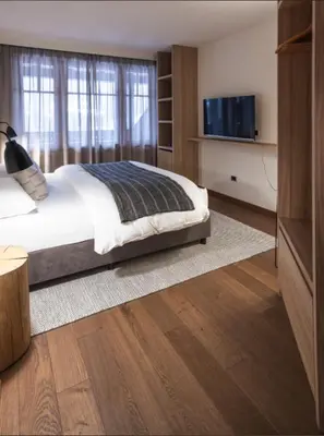 a bedroom with a bed and a flat screen tv at Hotel Bad Waldbrunn in Monguelfo
