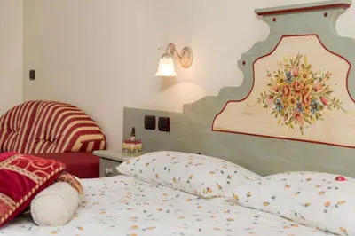 a bedroom with a bed with a wooden headboard at Garnì Val de Grepa in Pozza di Fassa