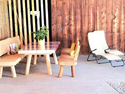a wooden table and chairs with a potted plant on a patio at zuLAVOGL in Kastelruth