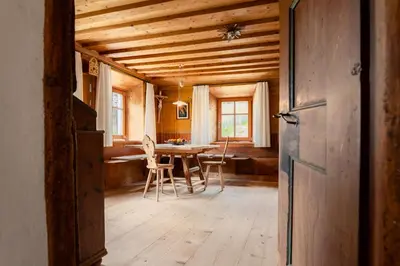 a room with a table and chairs and a wooden ceiling at zuLAVOGL in Kastelruth
