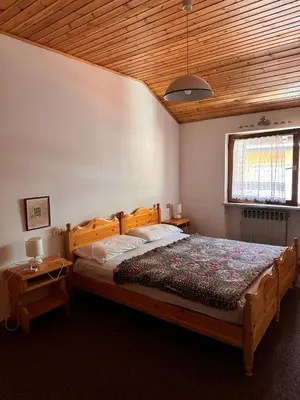 a bedroom with a bed and a wooden ceiling at Simi Dolomiti in Predazzo