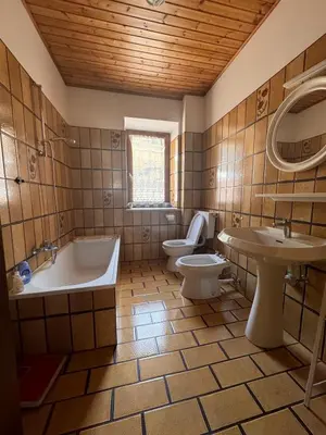 a bathroom with a tub and a toilet and a sink at Simi Dolomiti in Predazzo