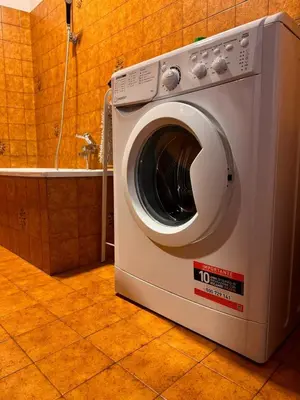 a washing machine sitting in a bathroom next to a tub at Simi Dolomiti in Predazzo
