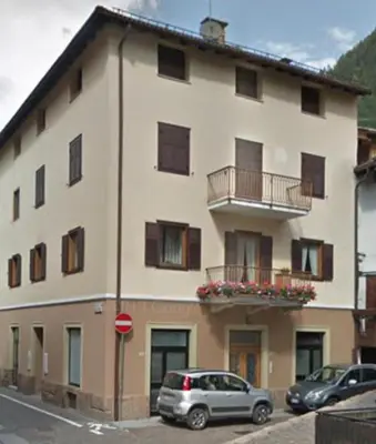 a large building with cars parked in front of it at Simi Dolomiti in Predazzo