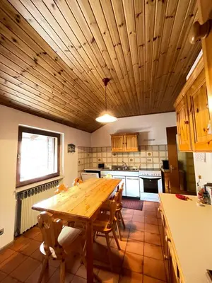 a kitchen with a wooden table and chairs at Simi Dolomiti in Predazzo
