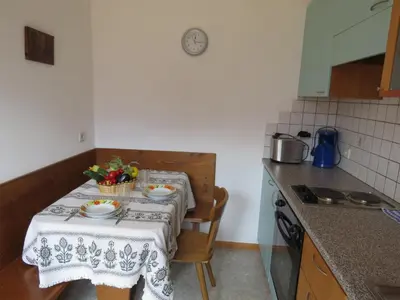 a small kitchen with a table with plates and flowers on it at Agriturismo Kabishof in Funes