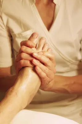 a woman clasping her hands on a persons leg at Agriturismo Kabishof in Funes