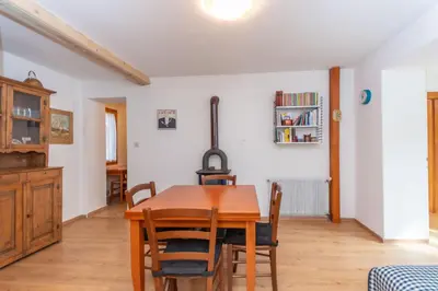 a dining room with a wooden table and chairs at Casa Col di Frena in Falcade