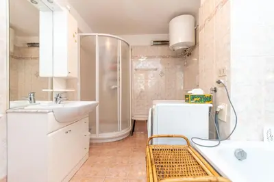 a bedroom with a white bed and two windows at Casa Col di Frena in Falcade
