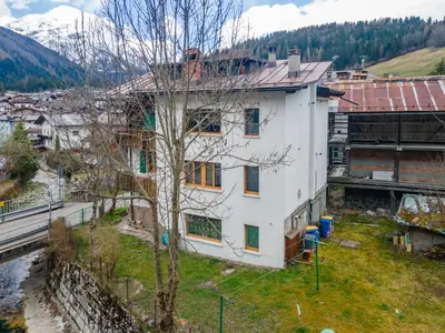 a house on a hill with mountains in the background at Casa Col di Frena in Falcade