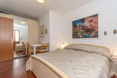 a bedroom with a bed and a table with chairs at Alpe Verde in Falcade
