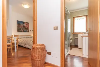 a room with a bedroom with a bed and a mirror at Alpe Verde in Falcade