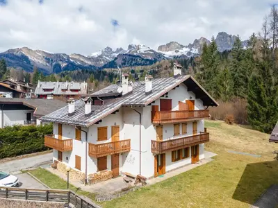 an aerial view of a house with mountains in the background at Alpe Verde in Falcade